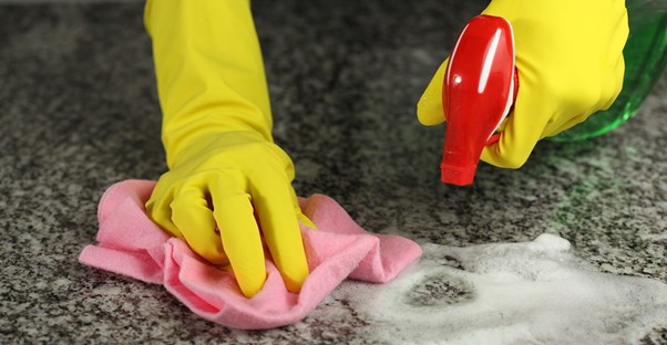 Woman cleaning her granite countertops