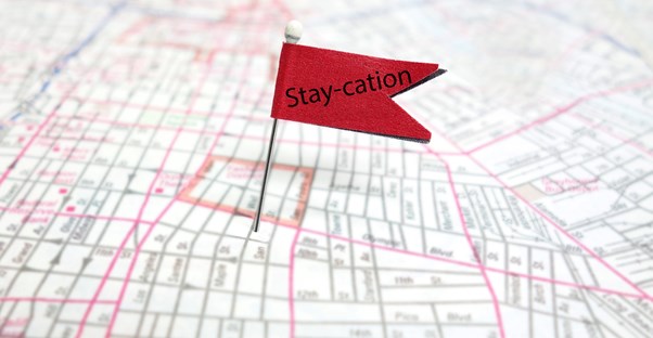 A flag pinned to someones hometown saying staycation