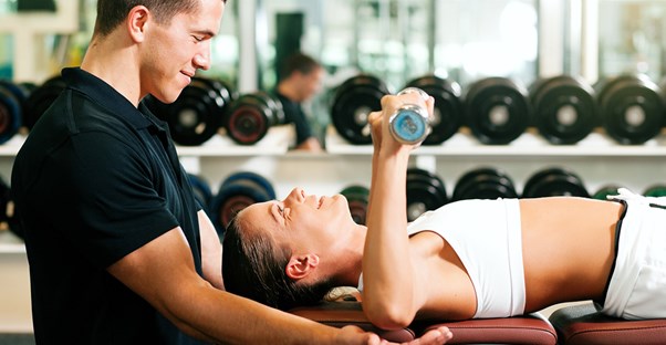 A personal trainer guiding a client through a workout