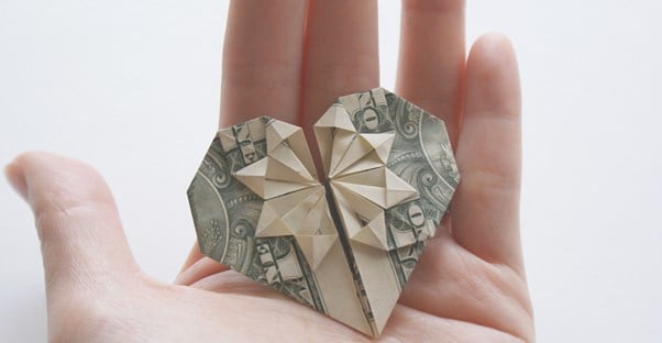 Money folded into a heart to represent donating to charity.