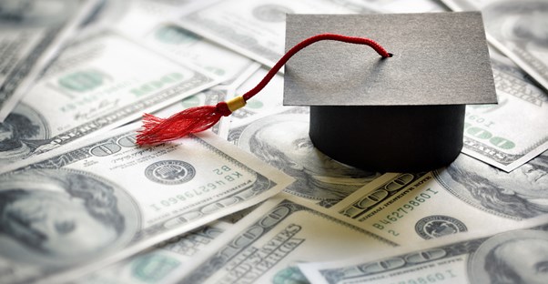 A graduation cap sitting on top of money