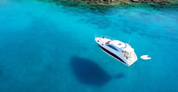 a boat covered by boat insurance on very clear blue water