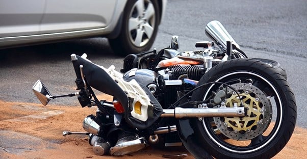 a motorcycle collapsed on the ground in a parking lot