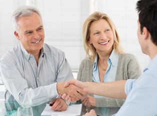 Insurance agent greets clients with a handshake