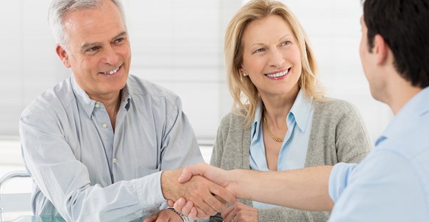 Insurance agent greets clients with a handshake