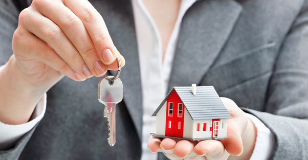 Person holding a key to a rental property covered by rental insurance