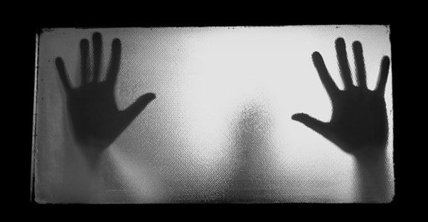 Two hands shadowed on a window