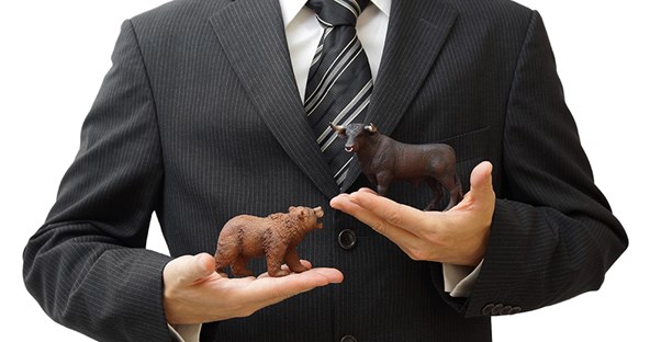 Man in a suit with hands holding figurines of a bear and a bull to represent trading styles in the options market