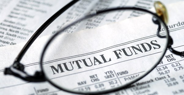 The lens of a pair of glasses magnifying the phrase mutual funds to represent how you should look closely at mutual funds to decide if they are a good investment for you.