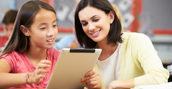 A tutor helps a student on a tablet