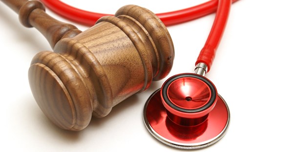 A wooden gavel and red stethoscope lying next to each other to represent the importance of using an accident injury lawyer after being injured in an accident.