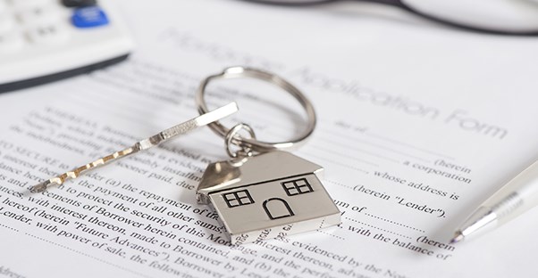 A key to a house on top of mortgage lending paperwork
