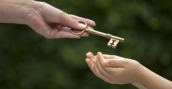 a child receiving a key to the inheritance from an adult