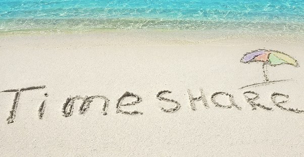 a scam advertisement of a beach with the word timeshare written in the sand