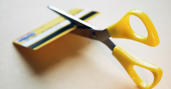scissors cutting a credit card in half as a step toward debt management
