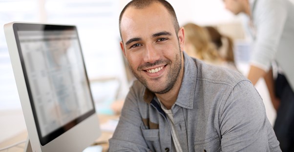 Man looking away from a computer where he is researching his new business idea
