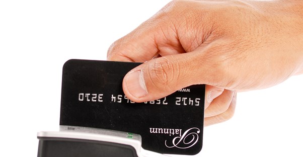 Male hand swiping a credit card and starting the credit card processing process