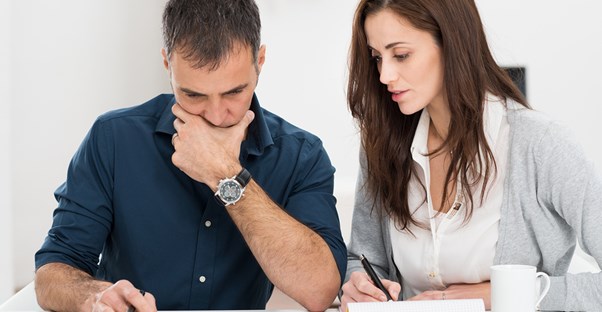 Husband and wife go over their expenses and income to make a plan to manage their money and budget.