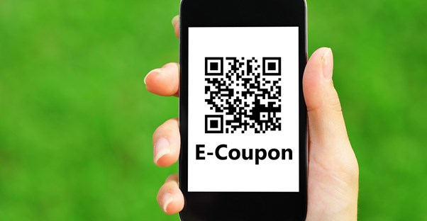An E-coupon reader pulled up on a smartphone as a woman uses coupon secrets to save money.