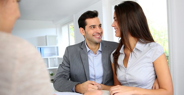 A couple smiles at each other as they apply for a home loan.