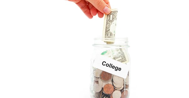 A recent college grad place money in a jar designated for paying off her college loan.