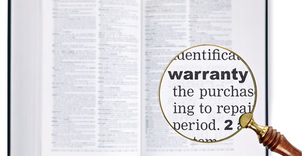 A magnifying glass over the word WARRANTY in a dictionary