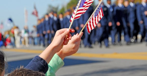 Children waving flags at a veteran parade