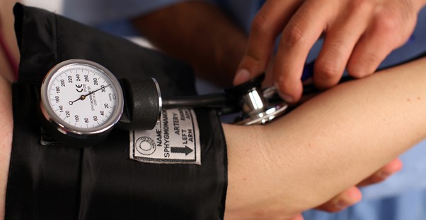a medical assistant measuring a patient's pulse