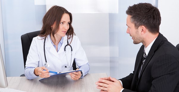 A doctor goes over forms with a patient