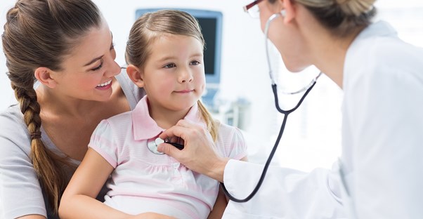 A pediatrician treats a young girl