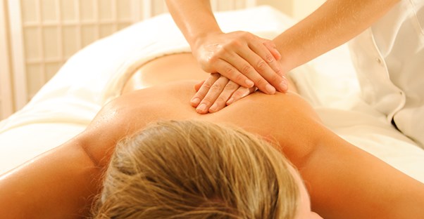 Massage therapy student practicing after choosing between online or on-campus programs