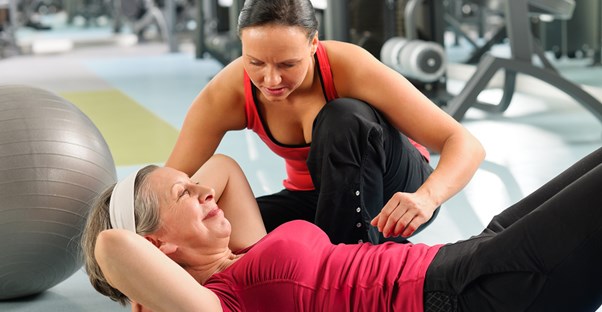A personal trainer works with a client