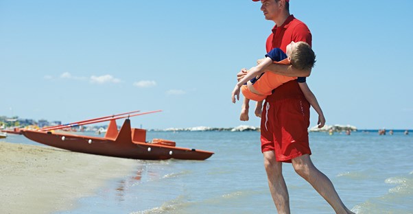A lifeguard saves a young boy
