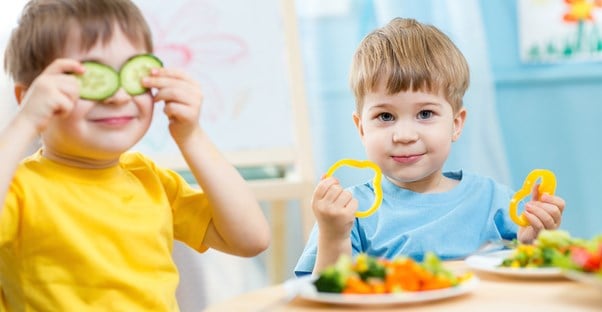 Young kids play with food in the cafeteria