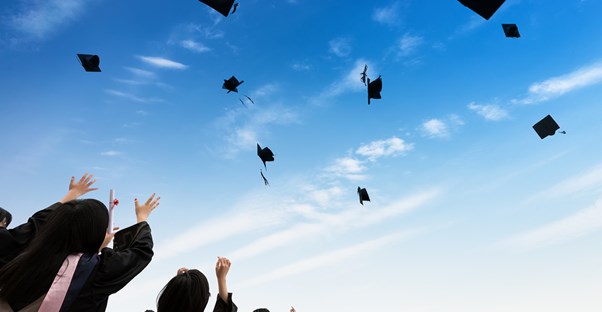 Graduates throw their caps