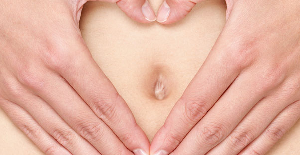 a woman holds her hands around her belly button and worries about toxoplasmosis during pregnancy