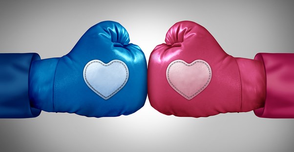 a male (blue) and female (pink) boxing glove with hearts on each fist bump in a sign of mutual respect