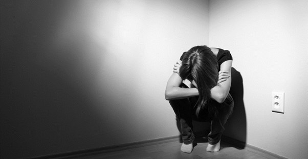 Victim of Domestic Violence hiding in a corner