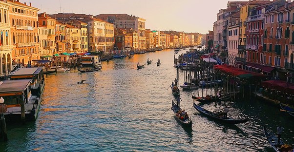 Boats float down a Venetian canal.