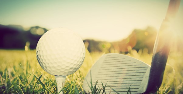 a close up shot of a golf ball about to be driven down a fairway