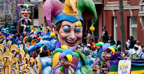 a mardi gras parade works its way down the street