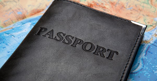 a passport travel wallet lies upon a map