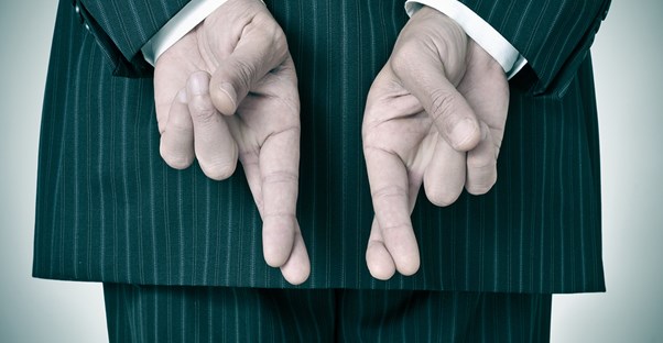 Person in green striped suit crosses his fingers behind his back