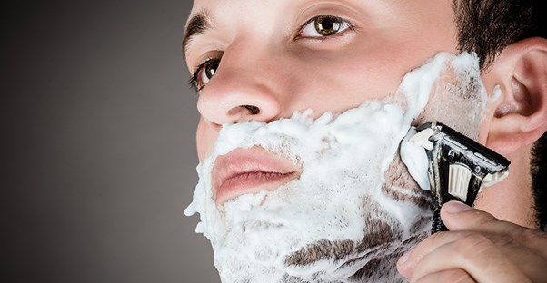 A guy shaves his beard