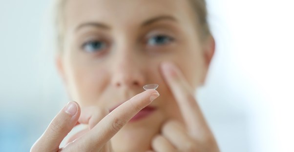 a woman holding contacts, an alternative to glasses