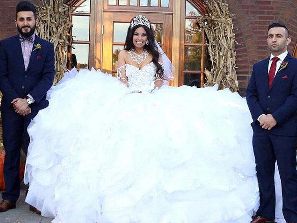 Here's why men are putting their heads in a bride's gown at wedding  receptions