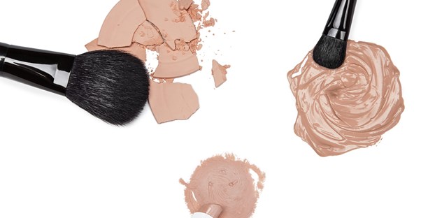 Makeup brushes laying next to piles of the best foundations