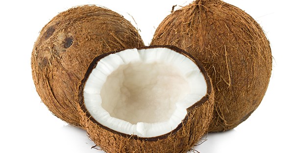 a whole coconut broken open to show its oil