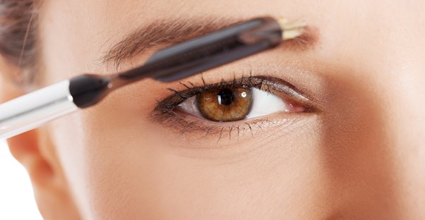 a woman tames her messy eyebrows