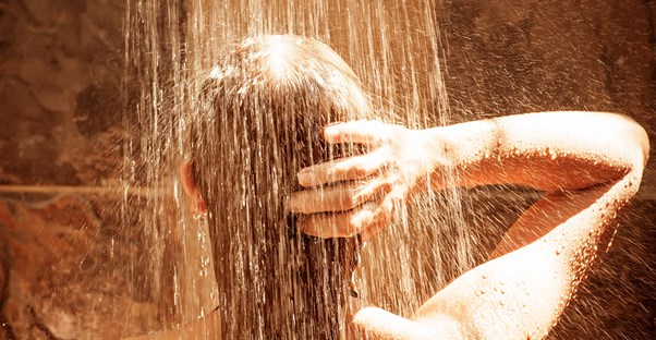 Woman washing her hair with a damaging shampoo
